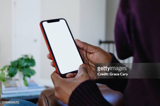 woman holds smart phone with blank screen - hand smartphone stock-fotos und bilder
