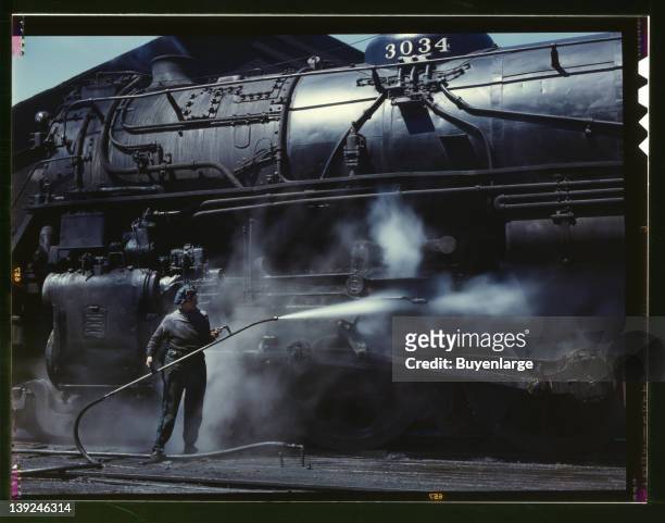 Viola Sievers, one of the wipers at the roundhouse, giving a giant H class locomotive a bath of live steam, Clinton, Iowa, 1943. Sievers is the sole...