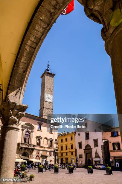 a glimpse of piazza del plebiscito seen from the colonnade of palazzo dei priori in the medieval heart of viterbo - naples italy church stock pictures, royalty-free photos & images