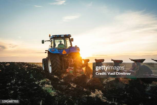 landwirt in traktor vorbereitung land mit nährboden cultivator - landwirtschaftliche maschine stock-fotos und bilder