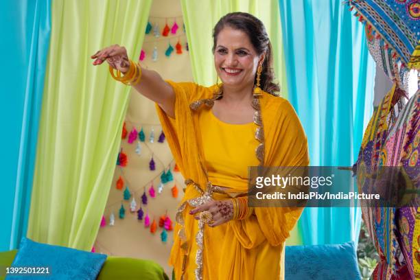 a portrait of an indian mother during her daughter's haldi ceremony - traditional clothing stock pictures, royalty-free photos & images