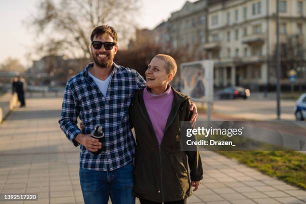 day in a life of female cancer patient - woman walking outdoors near river - couple short hair stock pictures, royalty-free photos & images