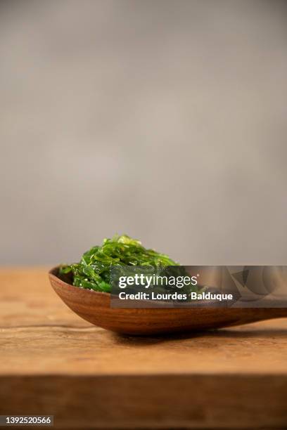 wakame seaweed on natural wood background - alge stock-fotos und bilder