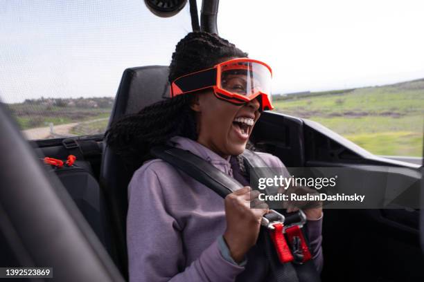 excited woman having fun while riding as a passenger on an off-road, side-by-side vehicle.  outdoor pursuit, hobby, and leisure activity. - side by side atv stock pictures, royalty-free photos & images