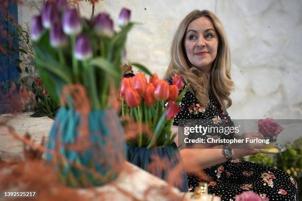Florist Sarah Richardson poses for the media as she prepares her 'English Afternoon Tea' themed display on the eve of the opening day of the...