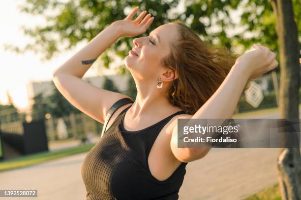 portrait of a beautiful young woman dancing in the city - große brüste stock-fotos und bilder