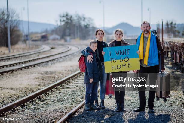 ukrainian refugee family in station waiting to leave ukraine due to the russian invasion of ukraine. - oost europese cultuur stockfoto's en -beelden