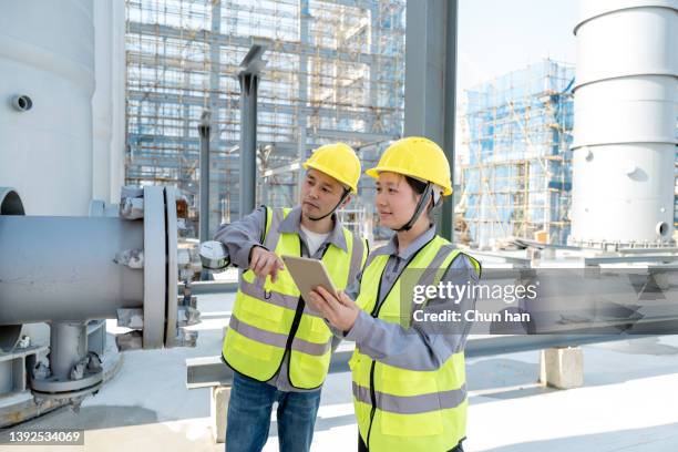 two male and female engineers are checking equipment in the chemical plant - sewage stockfoto's en -beelden