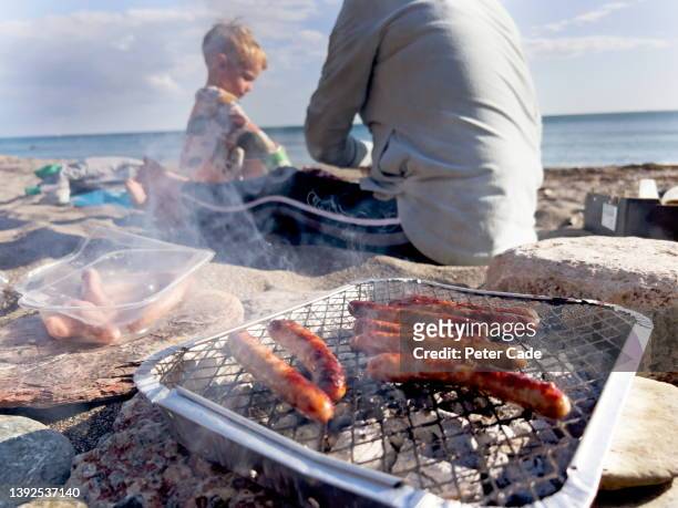sausages cooking on disposable barbecue - single use ストックフォトと画像