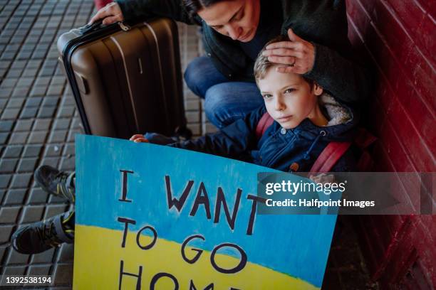 ukrainian refugee family in station waiting to leave ukraine due to the russian invasion of ukraine. - ukrainian culture stock pictures, royalty-free photos & images