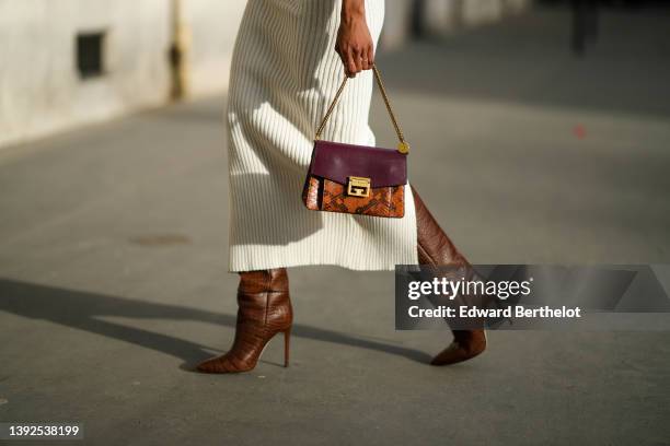 Emilie Joseph @in_fashionwetrust wears a white embossed checkered pattern high neck / sleeveless / midi wool tube slit dress, gold rings, a brown...