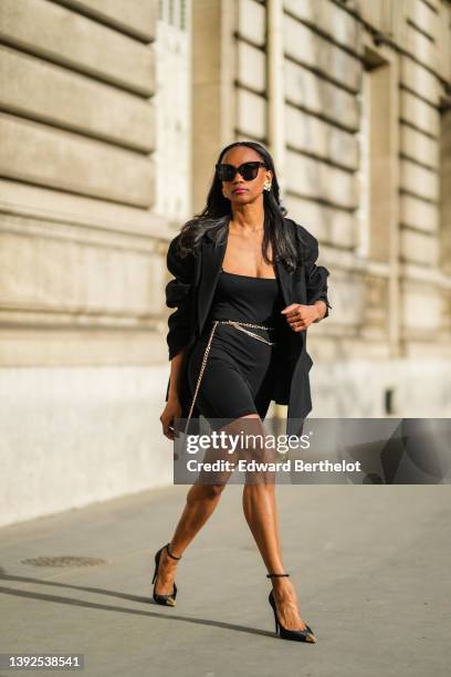 Emilie Joseph @in_fashionwetrust wears black sunglasses, gold large vintage earrings, a black oversized blazer jacket from Frankieshop, a black...