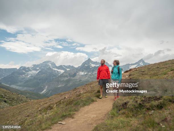 couple hike in the swiss alps - mid adult couple stock pictures, royalty-free photos & images