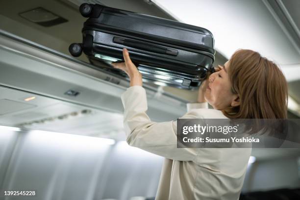 businesswoman traveling on an airplane to a business destination - cabin stock-fotos und bilder