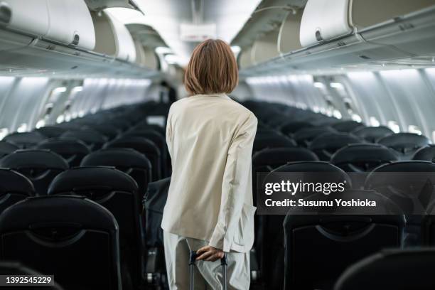 businesswoman traveling on an airplane to a business destination - air travel fotografías e imágenes de stock