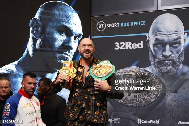 Tyson Fury reacts as he shows his WBC and Ring Magazine belts during a press conference ahead of the heavyweight boxing match between Tyson Fury and...
