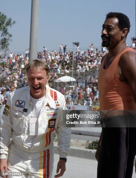 Racers Bobby Unser and Dan Gurney talk with NBA legend Wilt Chamberlain before the Toyota Long Beach Grand Prix race, April 13, 1985 in Long Beach,...