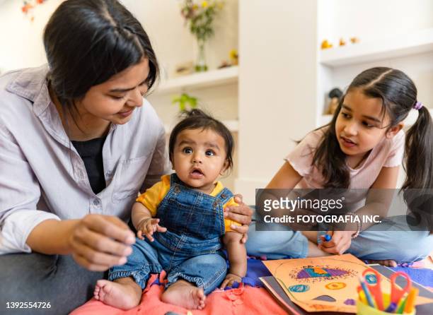 east indian mother and two young children playing - 6 11 maanden stockfoto's en -beelden