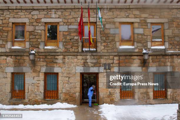 Woman clears snow from the entrance of the Navacerrada Town Hall, on 20 April, 2022 in Navacerrada, Madrid, Spain. Madrid has activated the Winter...