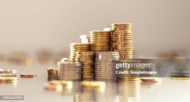 towers made out of gold and silver euro coins. - coins fotografías e imágenes de stock