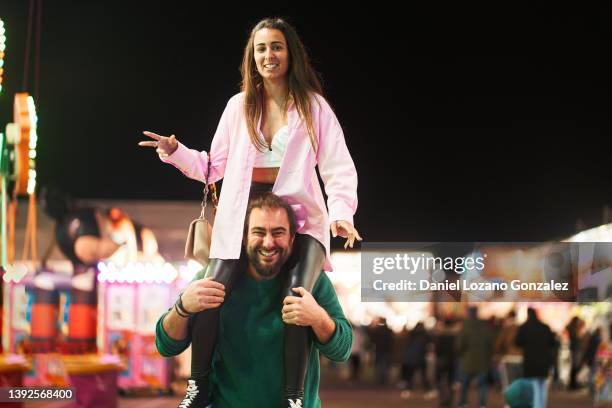 cheerful woman on shoulders of man - carrying on shoulders stock pictures, royalty-free photos & images
