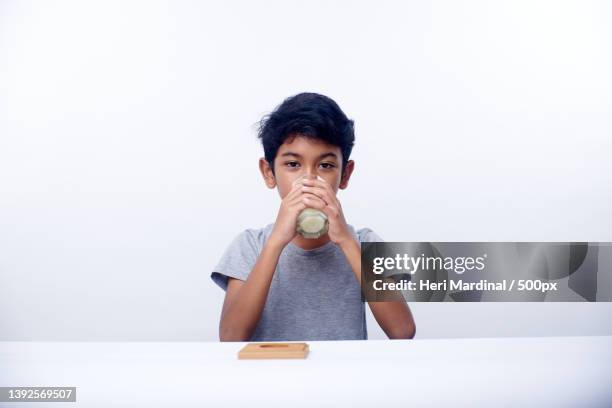 asian boy holds a glass of fresh milk,bali,indonesia - heri mardinal stock pictures, royalty-free photos & images