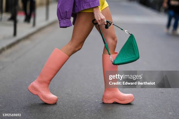 Almuneda Lapique wears a purple denim oversized jacket from Temps Des Cerises, pale yellow tweed high waist shorts, a silver ring, a green shiny...