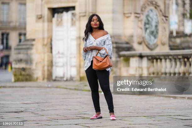 Carrole Sagba @linaose wears a pink lace pattern bra underwear, a pale blue and blue checkered braided wool pattern / buttoned oversized cardigan,...