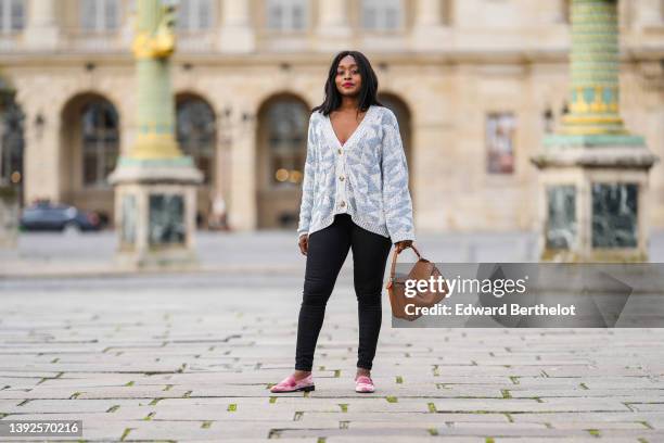 Carrole Sagba @linaose wears a pink lace pattern bra underwear, a pale blue and blue checkered braided wool pattern / buttoned oversized cardigan,...