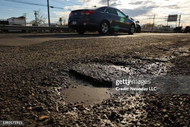 East Farmingdale, N.Y.: Vehicles pass over a rough roadway with potholes on Route 109, westbound, near E. Carmans Road in East Farmingdale, New York...