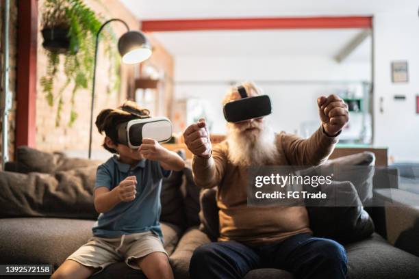 grandfather and grandson playing with vr glasses at home - game six stockfoto's en -beelden