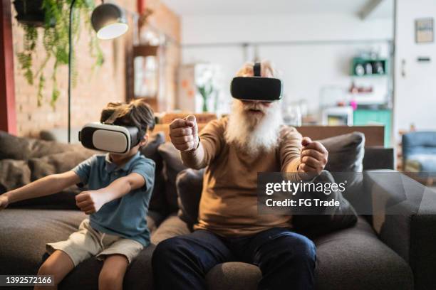 grandfather and grandson playing with vr glasses at home - vr kids stock pictures, royalty-free photos & images