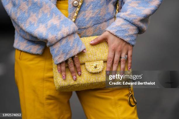 Gabriella Berdugo wears a pale blue and white houndstooth print pattern tweed jacket with white pearls buttons, high waist yellow shiny leather large...