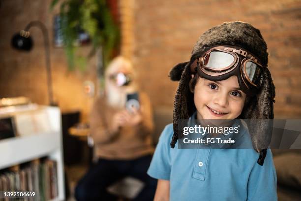 portrait d’un garçon heureux portant une casquette d’aviateur et des lunettes à la maison - lunettes daviateur photos et images de collection