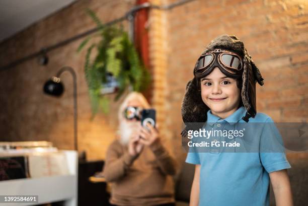 retrato de un niño feliz con gorra de aviador y gafas en casa - aviation hat fotografías e imágenes de stock