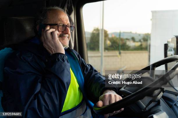 adult man talking on the phone in his truck. - old truck stock-fotos und bilder