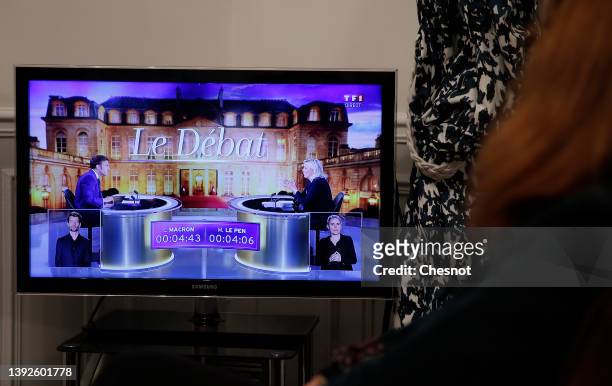 Member of the photographer’s family watches on television the debate between the leader of the far-right National Rally party, Marine Le Pen, and...