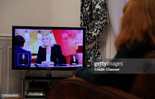 Member of the photographer’s family watches on television the debate between the leader of the far-right National Rally party, Marine Le Pen, and...