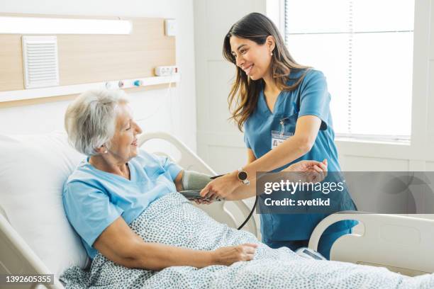 femme aîné dans le bâti d’hôpital - suivi des malades photos et images de collection
