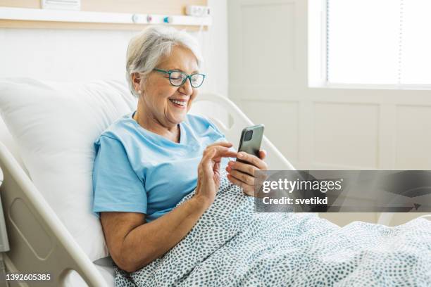 senior woman in hospital bed - hospital bed stock pictures, royalty-free photos & images