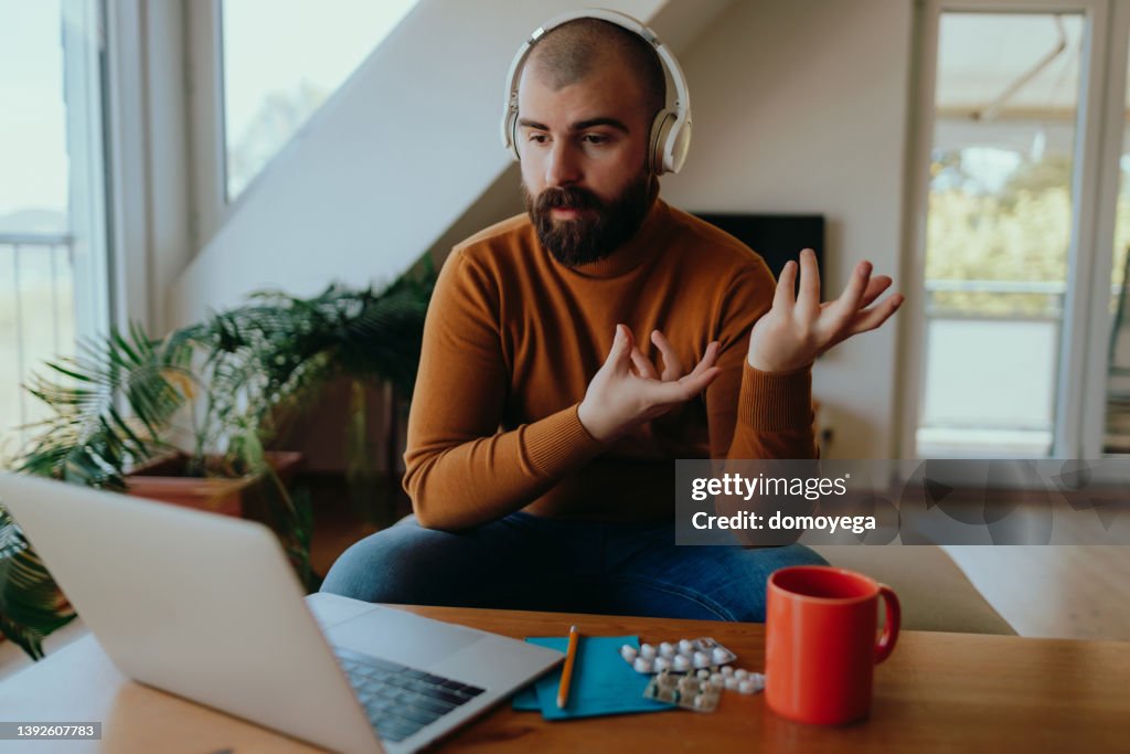 Young man having an online therapy session from home