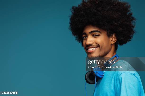 uomo afroamericano con l'acconciatura africana che usa il telefono - headphones isolated foto e immagini stock