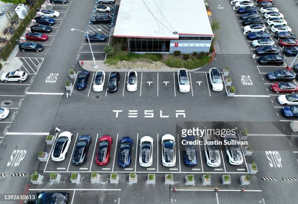 In an aerial view, Tesla cars sit parked in a lot at the Tesla factory on April 20, 2022 in Fremont, California. Tesla reported first quarter...