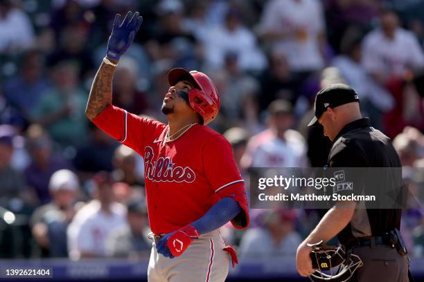 Johan Camargo of the Philadelphia Phillies gestures as he crosses home plate after hitting a three RBI home run against the Colorado Rockies in the...