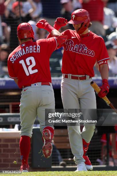 Kyle Schwarber of the Philadelphia Phillies is congratulated by Alex Bohn as he heads to the dugout after hitting a home run against the Colorado...