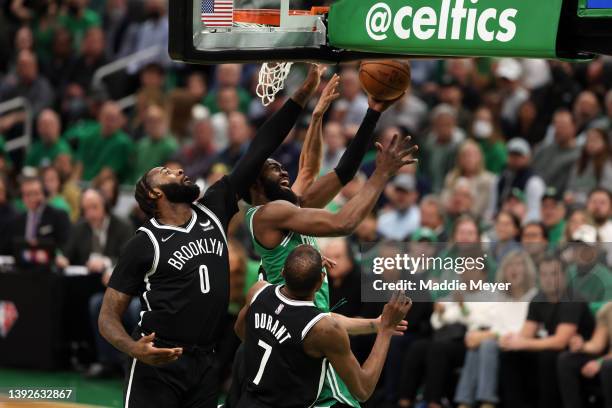 Jaylen Brown of the Boston Celtics takes a shot against Andre Drummond and Kevin Durant of the Brooklyn Nets during the first quarter of Game Two of...