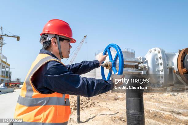 the male engineer is turning the valve - district heating plant stock pictures, royalty-free photos & images