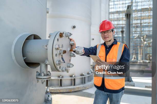 a male engineer is checking equipment in a chemical plant - inspectors stock pictures, royalty-free photos & images