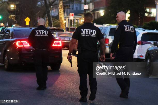 New York City police officer carries a gun recovered after an arrest on April 20, 2022 in the Flatbush neighborhood of Brooklyn borough in New York...