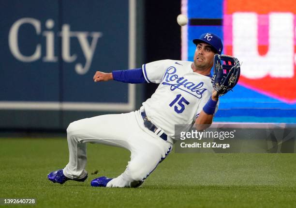 Whit Merrifield of the Kansas City Royals slides as he catches a ball off the bat of Gary Sanchez of the Minnesota Twins in the second inning at...